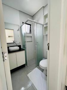 a bathroom with a glass shower and a toilet at MaxLoft apto completo cozinha e lavanderia in Joinville +17 photos