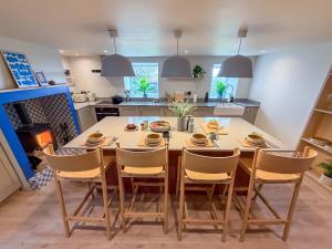 une cuisine avec une grande table et des chaises en bois dans l'établissement Luxury 4-Bed Farmhouse Retreat in Yorkshire Dales, à Gaisgill