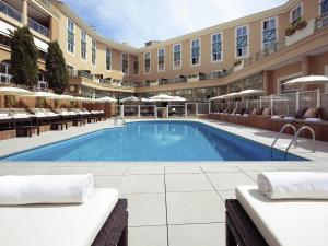 a large hotel with a swimming pool in a courtyard at Grand Hôtel Roi René Aix - MGallery Collection in Aix-en-Provence