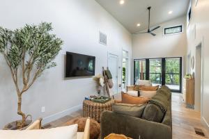 ein Wohnzimmer mit einem Sofa und einem Fernseher an der Wand in der Unterkunft Uncork & Unwind I Sip, Soak & Stroll Downtown Napa in Napa