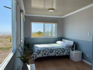 a small bedroom with a bed and a window at The Peninsula Resort in Mamburao