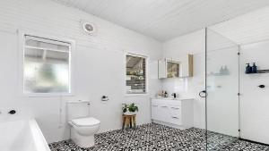 un bagno bianco con wc e doccia di Casita - Modern 4 Bedroom Cottage In Heart Of Singleton a Singleton Altre 2 foto