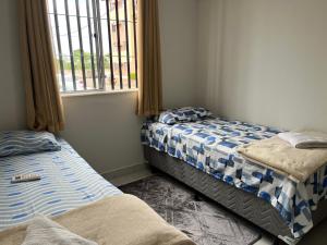 two beds in a room with a window at Apartamento térreo mobiliado sem escada p subir in Imperatriz +19 photos