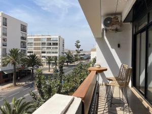a balcony with two chairs and a city street at Petit Bali 4-5px in Agadir