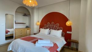 a bedroom with a large bed with a red headboard at Petit Bali 4-5px in Agadir
