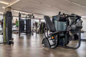 una palestra con macchinari per il cardio-fitness e persone sullo sfondo di Flat Lakeside Beira lago a Brasilia