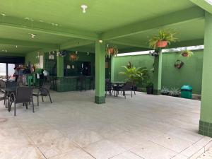 a restaurant with green walls and tables and chairs at Apartamento térreo mobiliado sem escada p subir in Imperatriz