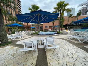 a group of chairs and an umbrella next to a pool at Times Square Hotel Service Apartment At Kl in Kuala Lumpur