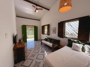 une chambre avec un lit et un salon dans l'établissement Pousada Canto da Reg, à Santa Cruz Cabrália