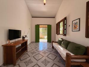 un salon avec un canapé et une télévision à écran plat dans l'établissement Pousada Canto da Reg, à Santa Cruz Cabrália