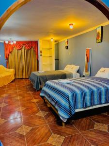 Hospedaje Carrasco Cajamarca في كاخاماركا: غرفة بسريرين في غرفة ذات أرضيات خشبية