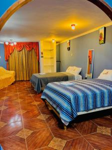 Hospedaje Carrasco Cajamarca في كاخاماركا: غرفة بسريرين في غرفة ذات أرضيات خشبية