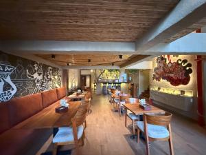 a restaurant with wooden tables and chairs and a wall with graffiti at Hotel Quincha y Adobe in Huanchaco