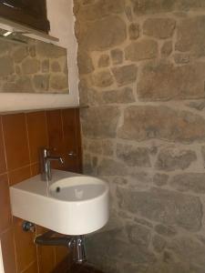 AgramuntにあるLa Caseta de JIOの洗面台と石の壁のあるバスルーム