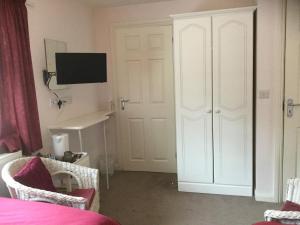 a bedroom with a white door and a bed and a desk at Pen-y-Bont Guest House in Amroth