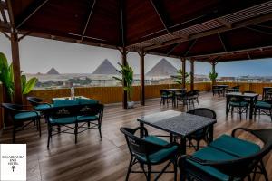 a restaurant with tables and chairs with pyramids in the background at Casablanca pyramids inn in Cairo