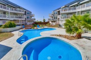 - une piscine en face d'un immeuble dans l'établissement Steps to Shore Condo with Balcony in Port Aransas, à Mustang Beach