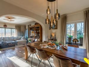 Una sala de estar con una gran mesa y sillas de madera. en Wezelhoeve, en Balen