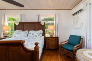 Un dormitorio con una cama y una silla azul. en Spacious Bayfront Home with Pool, Dockage, Beach, Kayaks and More, en Islamorada 61 fotos más
