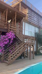 una casa con fiori viola accanto a una piscina di Villas de Portugal - Apartamento com suíte e Varanda Gourmet, Piscina - Praia do Ervino a São Francisco do Sul