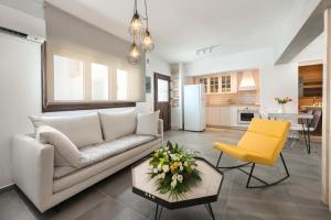 a living room with a white couch and a yellow chair at Lindos 4 me Studios in Lindos