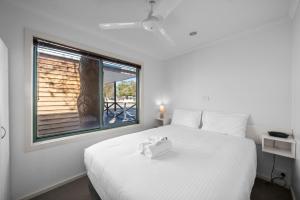 a bedroom with a white bed and a window at Shepparton Holiday Park and Village in Shepparton +45 photos