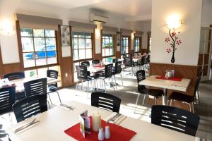 a dining room with tables and chairs and windows at Bandicoot Motor Inn Hamilton in Hamilton
