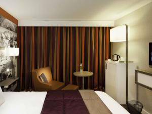 une chambre d'hôtel avec un lit, une chaise et une table dans l'établissement Mercure Chambéry Centre, à Chambéry