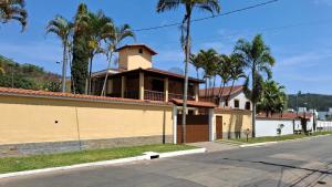 a house on the side of a street with palm trees at Casa Jardim da Serra in Juiz de Fora