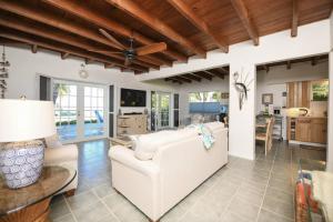 a living room with a white couch and a table at Charming Bayfront Cottage in Heart of Islamorada with Pool, Dockage, Beach, Kayaks & More in Islamorada