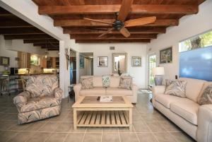 a living room with couches and a ceiling fan at Charming Bayfront Cottage in Heart of Islamorada with Pool, Dockage, Beach, Kayaks & More in Islamorada