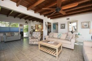 a living room with couches and a ceiling fan at Charming Bayfront Cottage in Heart of Islamorada with Pool, Dockage, Beach, Kayaks & More in Islamorada