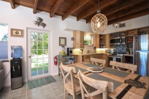 a kitchen with a table and chairs and a refrigerator at Charming Bayfront Cottage in Heart of Islamorada with Pool, Dockage, Beach, Kayaks & More in Islamorada +33 photos