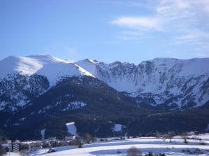 a snow covered mountain range with a town in the foreground at La Maison Bleue in La Cabanasse