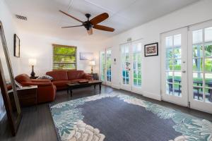 a living room with a couch and a ceiling fan at Private Cottage on Bayfront Estate with Pool, Beach, Dockage, Kayaks and More in Islamorada