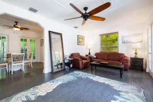 a living room with a couch and a ceiling fan at Private Cottage on Bayfront Estate with Pool, Beach, Dockage, Kayaks and More in Islamorada +39 photos