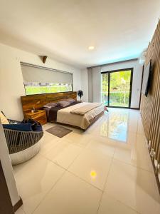 a bedroom with a bed and a television on a tiled floor at Cabaña en santafe de Antioquia in Santa Fe de Antioquia