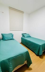 zwei Betten nebeneinander in einem Zimmer in der Unterkunft 1102 apto 2 Qtos-Wi-Fi-Piscina-Verão-Varanda-Vista in Ilha da Restinga