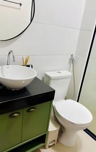 ein Badezimmer mit einer weißen Toilette und einem Waschbecken in der Unterkunft 1102 apto 2 Qtos-Wi-Fi-Piscina-Verão-Varanda-Vista in Ilha da Restinga