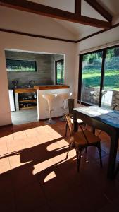 a living room with a table and chairs and a sink at Cabaña Velo de la Novia II - Siete Tazas in Molina