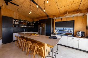 a kitchen with a large kitchen island with bar stools at Ocean View Escape in Sandy Beach +11 photos