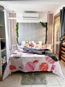 Un dormitorio con una cama grande con una colcha floral. en Love room, en Basse-Terre