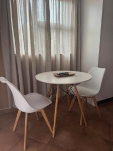 una mesa y dos sillas blancas y una mesa en Cozy Place in Windhoek, en Windhoek