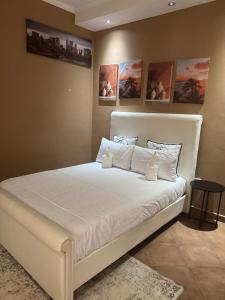 Un dormitorio con una cama blanca en una habitación. en Cozy Place in Windhoek, en Windhoek