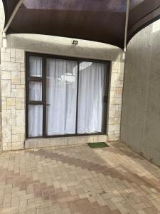 una ventana con una cortina blanca en una habitación en Cozy Place in Windhoek, en Windhoek