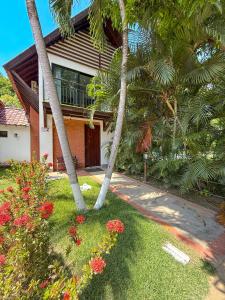 a house with palm trees and flowers in front of it at Cabaña en santafe de Antioquia in Santa Fe de Antioquia +36 photos