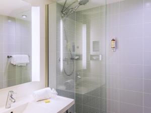 a bathroom with a glass shower and a sink at Hotel Mercure Toulouse Centre Compans in Toulouse