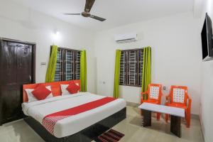 une chambre avec un lit et deux chaises orange dans l'établissement Hotel O Sai Miracle Stays - 2, à Bhubaneswar