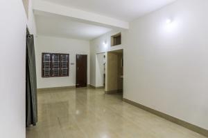 - un couloir avec des murs blancs et du carrelage dans l'établissement Hotel O Sai Miracle Stays - 2, à Bhubaneswar