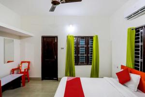 - une chambre avec un lit et une fenêtre avec des rideaux verts dans l'établissement Hotel O Sai Miracle Stays - 2, à Bhubaneswar